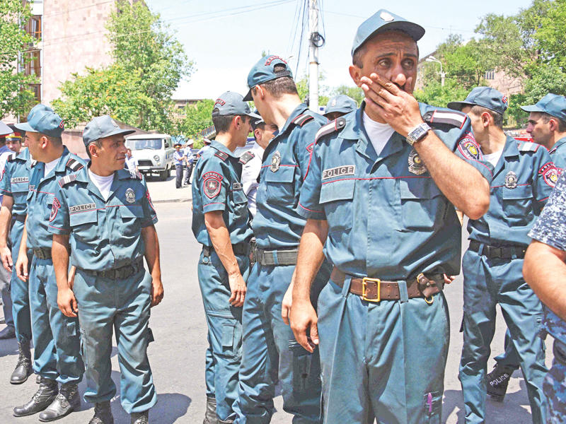 شرطيون أرمن ينتشرون قرب مقر الشرطة المسيطر عليه في يرفان أمس (أ ف ب)