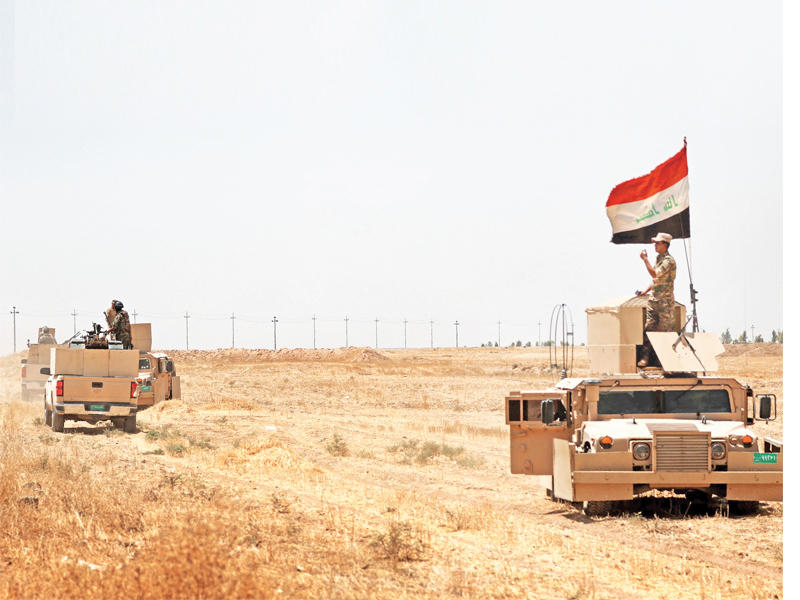جندي عراقي يرفع العلم في منطقة مخمور أمس الأول  (أ ف ب)
