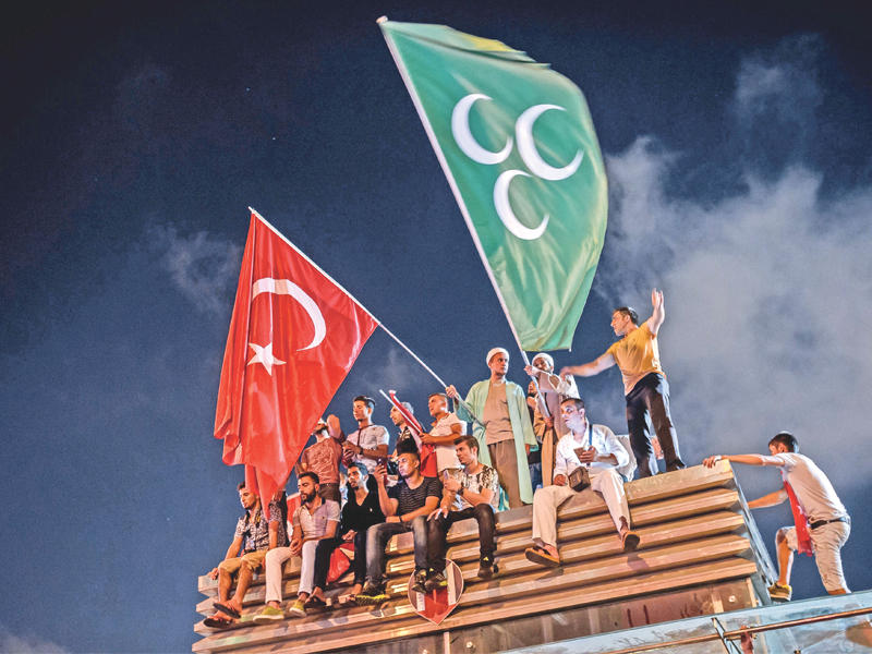 أتراك يلوحون بعلم تركيا الحديثة وعلم السلطنة العثمانية خلال تجمع في ساحة تقسيم وسط اسطنبول مساء أمس الأول                   (أ ف ب)