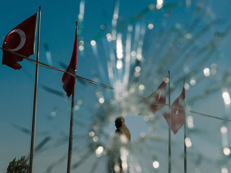 صورة مأخوذة في 19 يوليو ويظهر بها تمثال لمؤسس تركيا الحديثة مصطفى كمال أتاتورك من خلال ثقب في نافذة مقر شرطة أنقرة بعد أن تعرض للقصف خلال محاولة الانقلاب فاشلة.