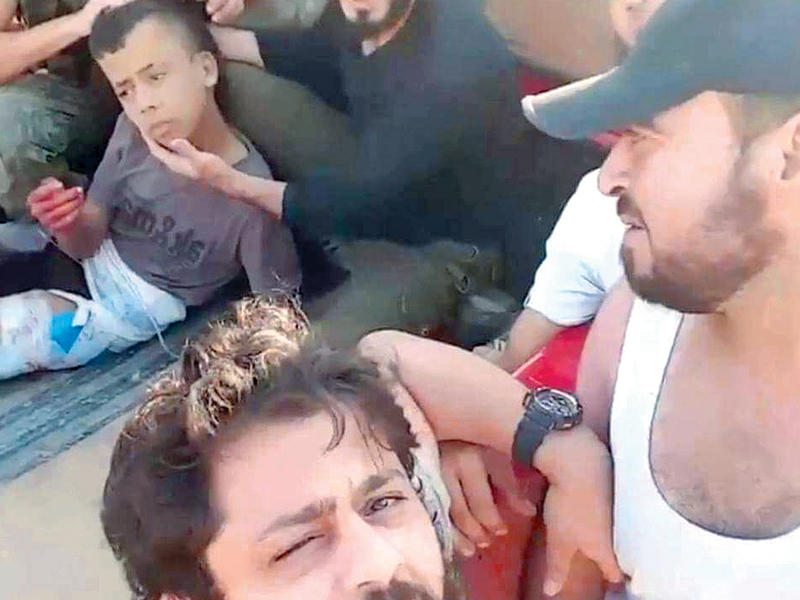 صورة مأـخوذة عن الفيديو للفتى الذي ذلح بين مقاتلي حركة «زنكي» في حلب قبل دقائق من قطع عنقه بطريقة وحشية  