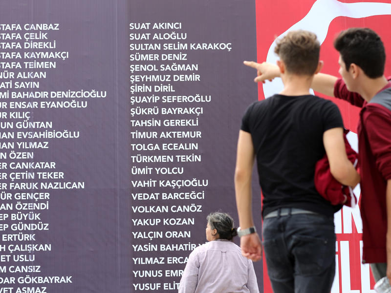 أتراك أمام لافتة كبيرة تحمل أسماء ضحايا محاولة الانقلاب في اسطنبول