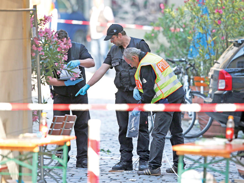 عناصر من الشرطة الألمانية تحقق في موقع هجوم أنسباخ جنوب ألمانيا أمس (أ ف ب)