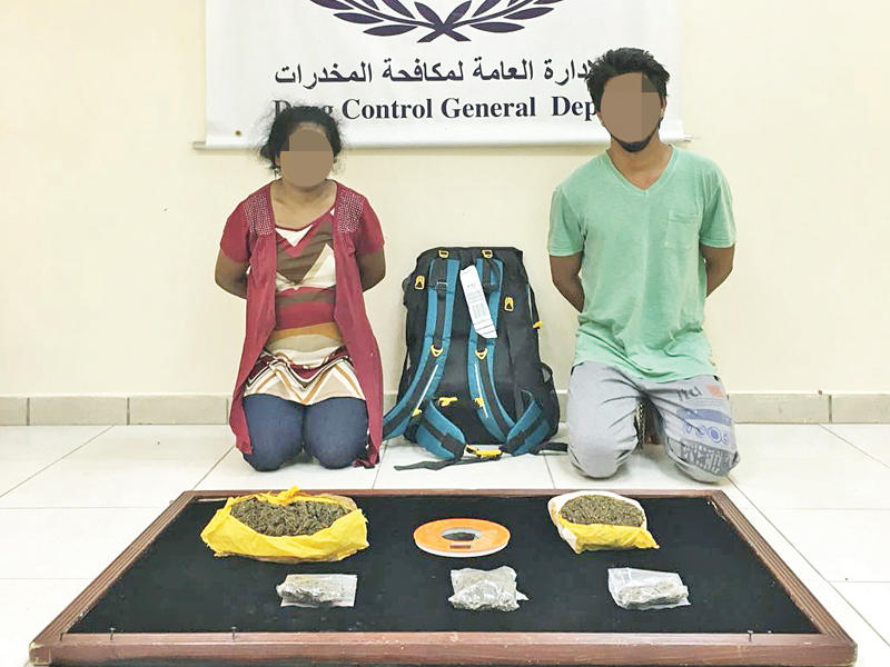 المتهمان وأمامهما المضبوطات