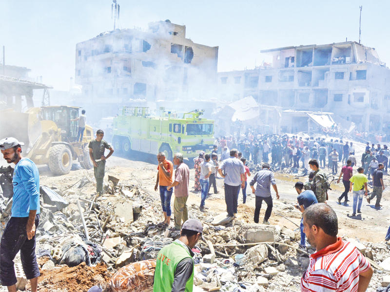 أكراد يبحثون عن ناجين تحت أنقاض مبنى دمره التفجير الانتحاري بالقامشلي أمس  (رويترز)