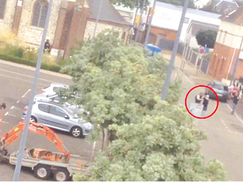 صورة مأخوذة عن شريط مصور تظهر أحد المهاجمين وهو يقتاد راهبة كدرع بشري خارج الكنيسة قبل أن تتمكن الشرطة من قتله