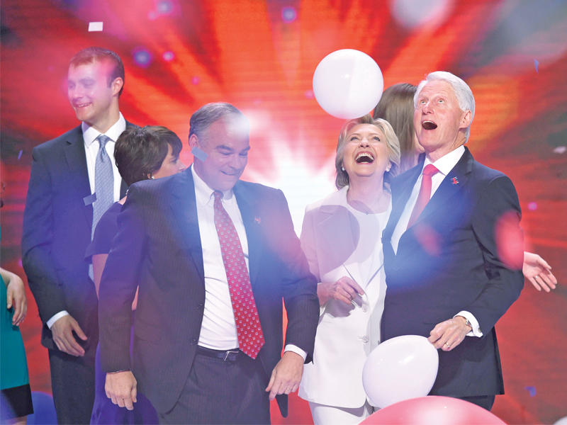 كلينتون وزوجها بيل وكين وزوج ابنتها أثناء الاحتفال على المسرح في فيلادلفيا أمس الأول (أ ف ب)