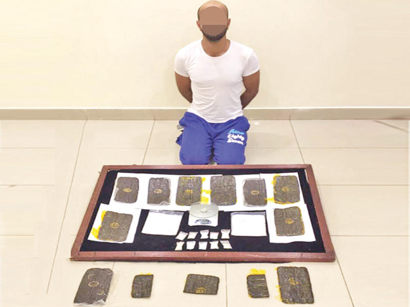 المتهم وأمامه المضبوطات