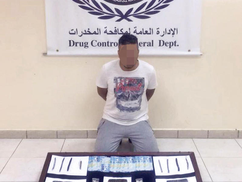 المتهم وأمامه المضبوطات