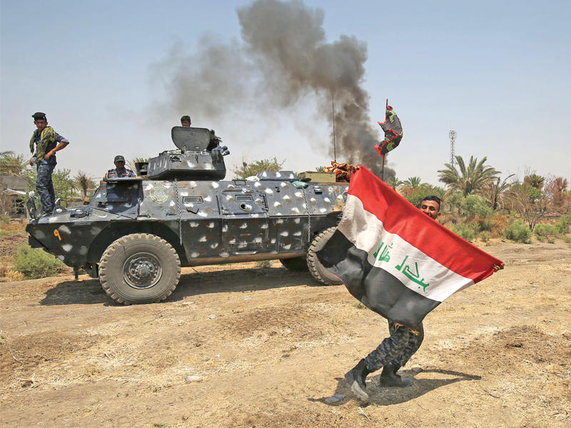 جنود عراقيون يرفعون العلم في جزيرة الخالدية أمس الأول (أ ف ب)