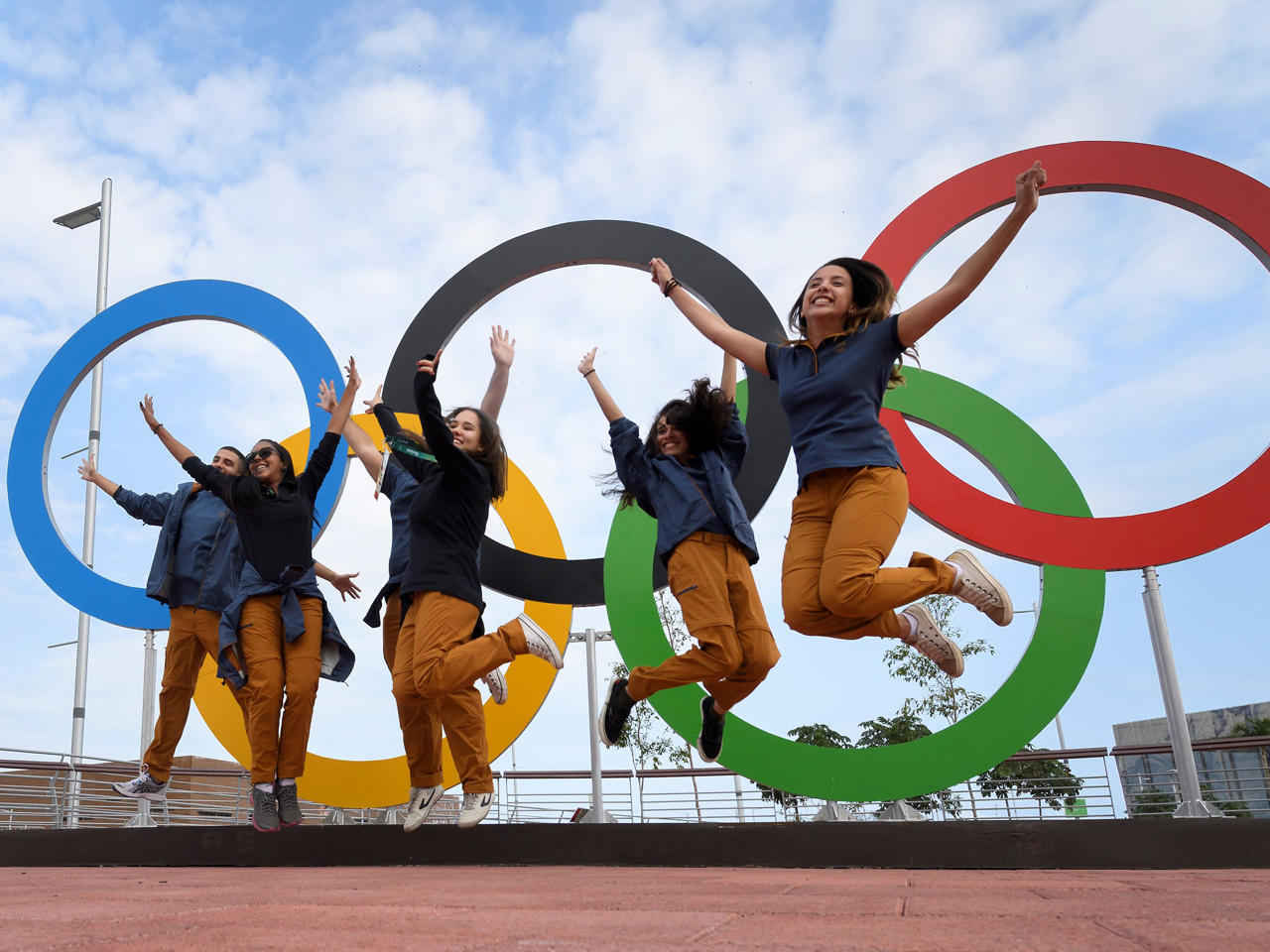 فتيات يلتقطن صورة مع الشعار الأولمبي عند مدخل القرية الأولمبية في ريو دي جانيرو