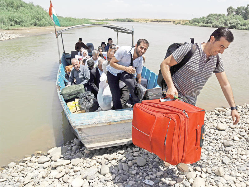 سوريون نازحون الى إقليم كردستان العراق عبر نهر الفرات (أ ف ب)
