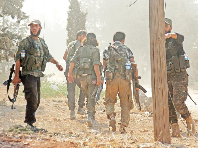 مقاتلو «جبهة الفتح» يدخلون مدرسة التسليح جنوب حلب أمس (أ ف ب)