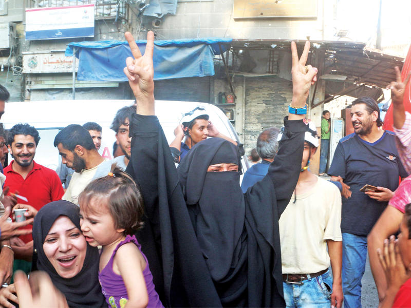 منتقبة سورية ترفع شارة النصر فرحاً بكسر الحصار عن شرقي حلب أمس الأول  (رويترز)