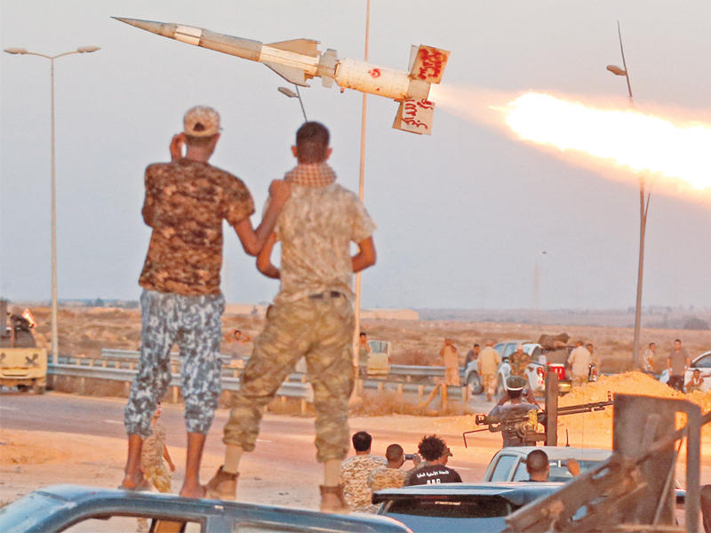 مقاتلو حكومة الوفاق يتابعون إطلاق صاروخ على مواقع «داعش» الخميس الماضي (رويترز)