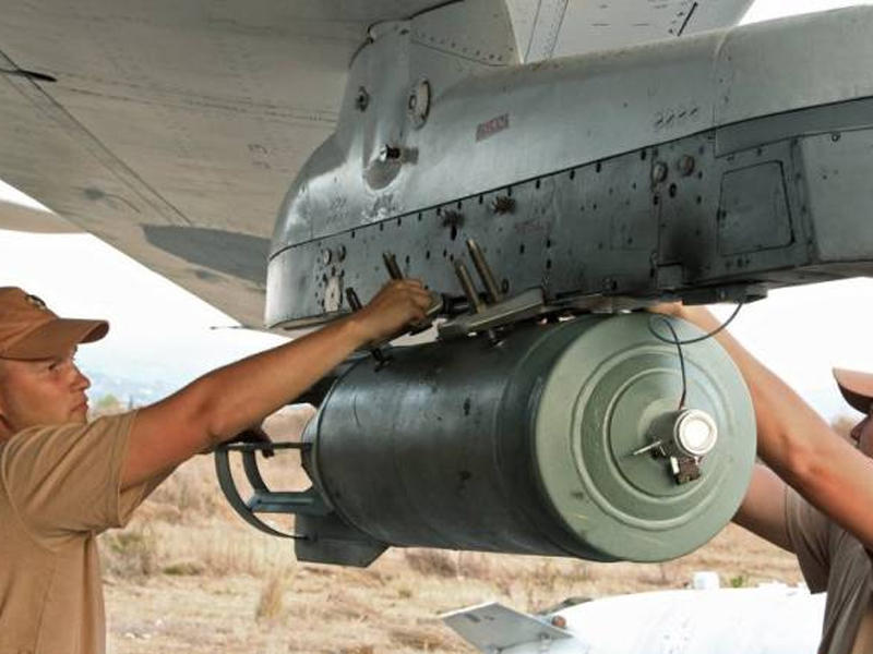 جنود روس يثبتون أحد القنابل على مقاتلة رابضة في قاعدة حميميم الجوية (ارشيف)