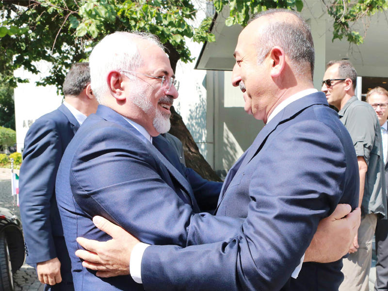 جاويش أوغلو معانقاً ظريف في أنقرة أمس (أ ف ب)