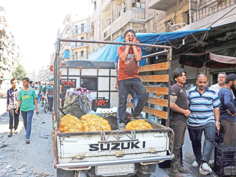 سوري ينادي أمس الأول على البطاطا في سوق شرق حلب بعد انقطاعها طوال مدة الحصار ( أ ف ب)