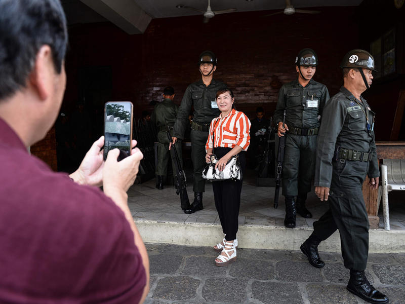 سائحة تلتقط صورة تذكارية مع عسكريين تايلنديين في أحد شوارع العاصمة بانكوك وسط تشدد أمني كبير بعد الانفجرات الأخيرة التي ضربت البلاد (ا ف ب)