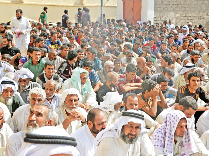 عدد من أهالي القيارة جنوب الموصل الفارين من بطش «داعش» أمس  (رويترز)