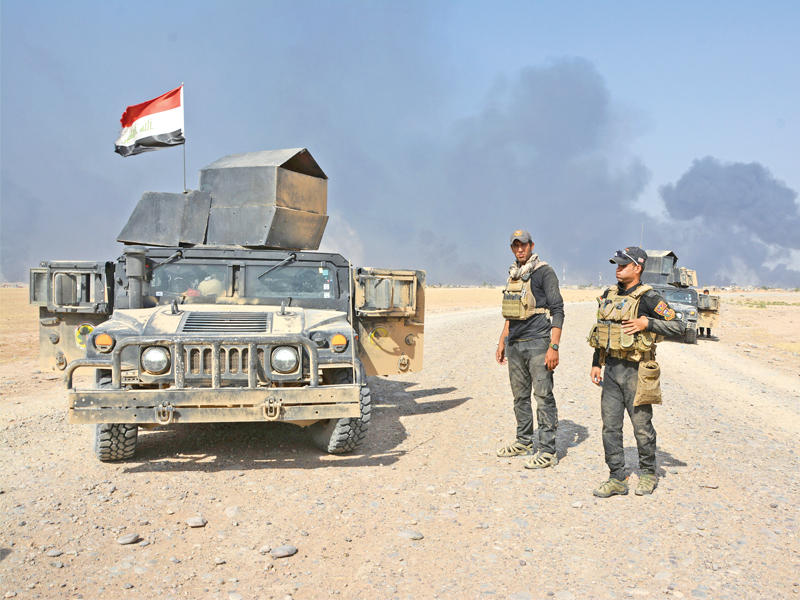 جنديان عراقيان بمركبتهما على مشارف القيارة أمس (رويترز)