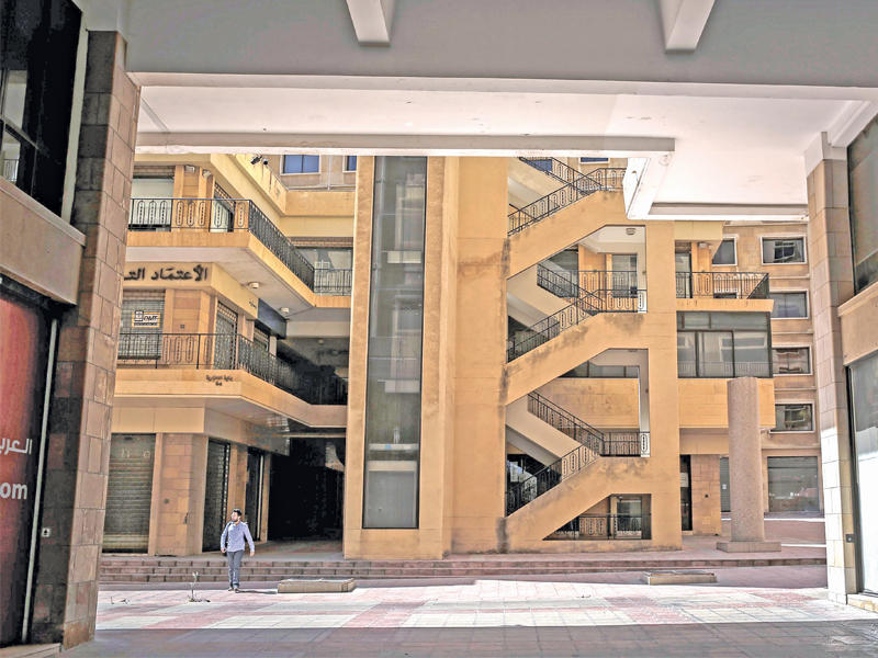 لبناني يسير بجانب مبنى تجاري شبه خال في وسط بيروت لتردي الأوضاع الاقتصادية أمس                 (اي بي ايه)