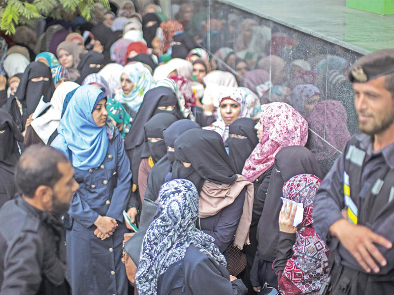 غزيون ينتظرون تسلم رواتبهم أمس (أ ف ب)