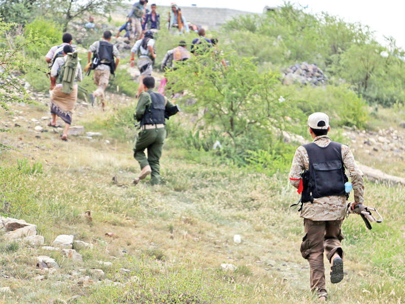 مقاتلون موالون للرئيس هادي يعتلون قمة تل في تعز أمس (أ ف ب)