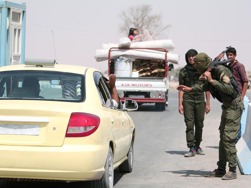 مقاتلون أكراد يدققون على هويات المارة