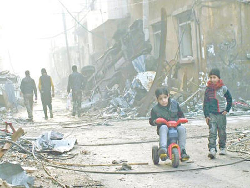 طفل سوري يلهو بدراجته في أحد أحياء حمص المدمرة أمس الأول (رويترز)