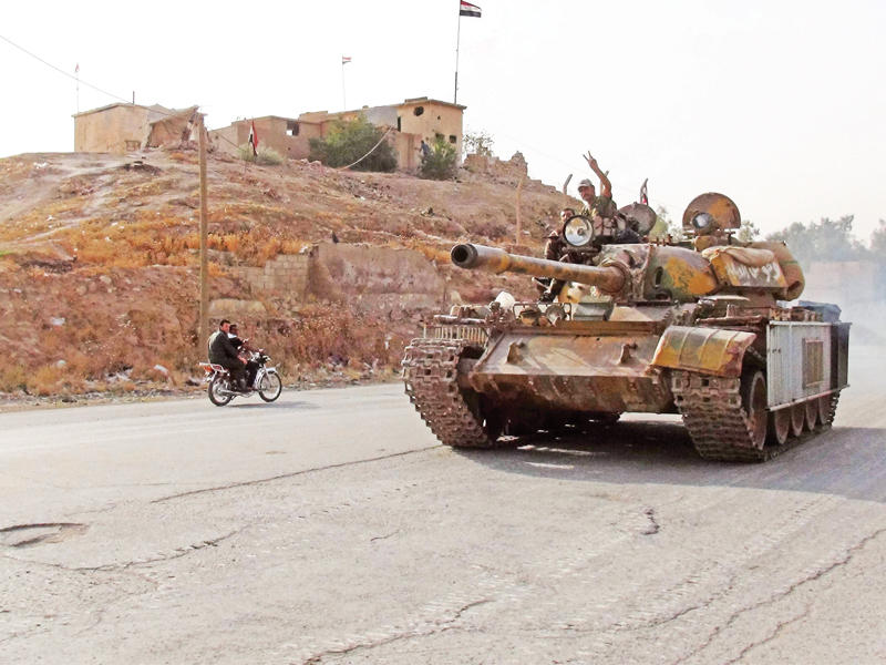  جندي سوري يرفع شارة النصر على دبابة في حي غويران بالحسكة أمس الأول   (أ ف ب)