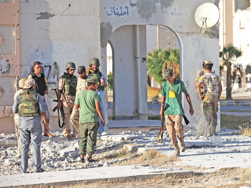 مقاتلو الحكومة يتحصنون بمبنى وسط سرت أمس الأول  (رويترز)