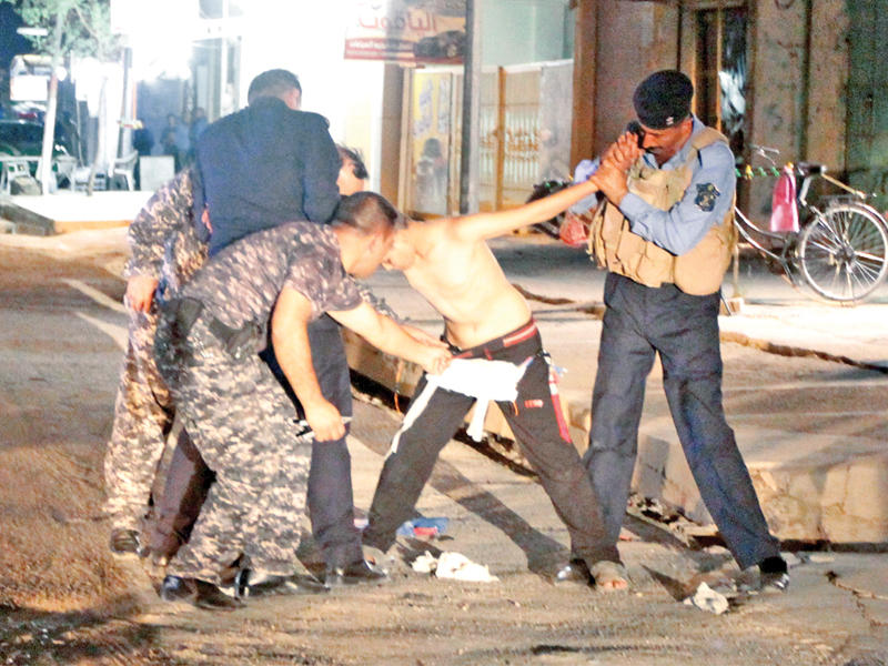 جنود يجردون صبياً من حزامه الناسف في كركوك أمسn(رويترز)