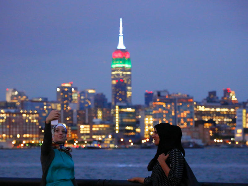 فتاتان تلتقطان صورة سيلفي ويبدو من خلفهما برج امباير الشهير
