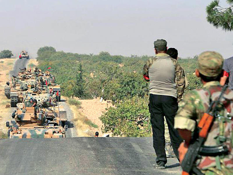 جنود أتراك يتابعون انطلاق أرتال الدبابات إلى الحدود السورية أمس (الأناضول)