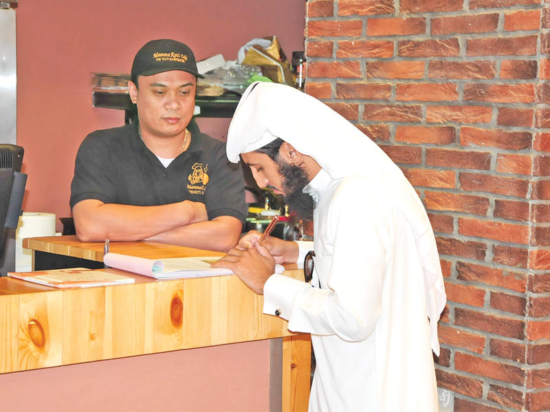 موظف البلدية أثناء تحريره مخالفة لأحد المقاهي