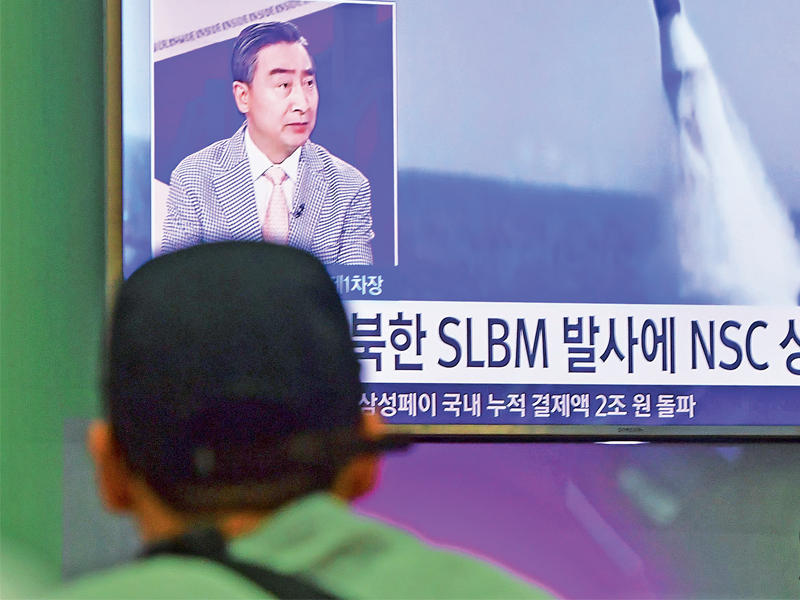 مواطن كوري جنوبي يشاهد عملية إطلاق الصاروخ  من سيول أمس (أ ف ب)