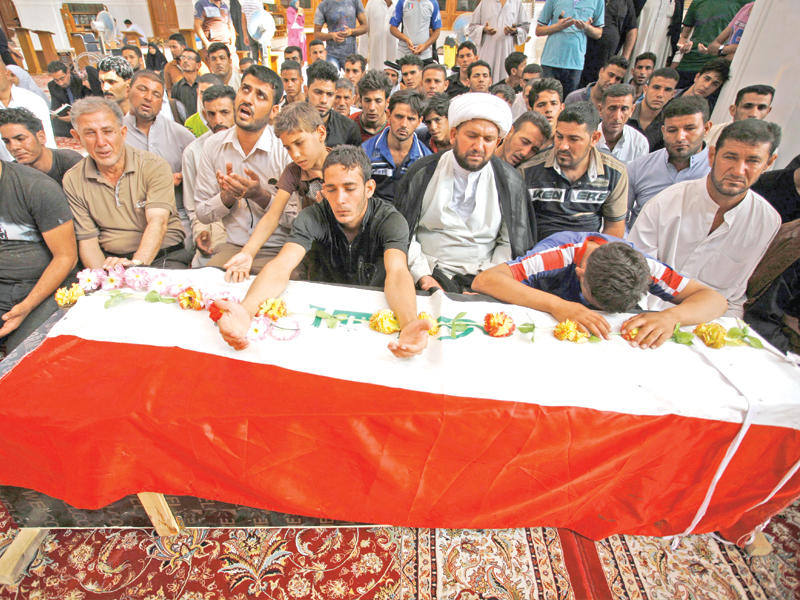 عراقيون يشيعون عنصراً من الحشد الشعبي قتل ضمن الحرب على «داعش» في النجف أمس  (أ ف ب)