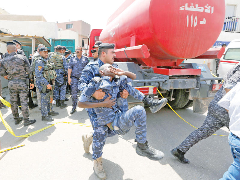 جندي ينقله زميلاً أصيب في حريق مستشفى بغداد أمس الأول (رويترز)