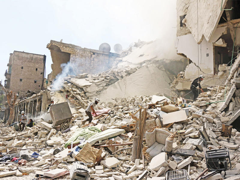 عمال إنقاذ يبحثون عن ناجين تحت أنقاض مبنى دمره برميل متفجر شرق حلب أمس  (أ ف ب)