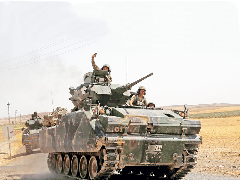 ناقلات جند تركية تتجه إلى حدود سورية أمس (رويترز)