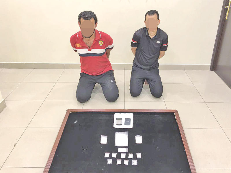 المتهمان وأمامهما المواد المخدرة المضبوطة