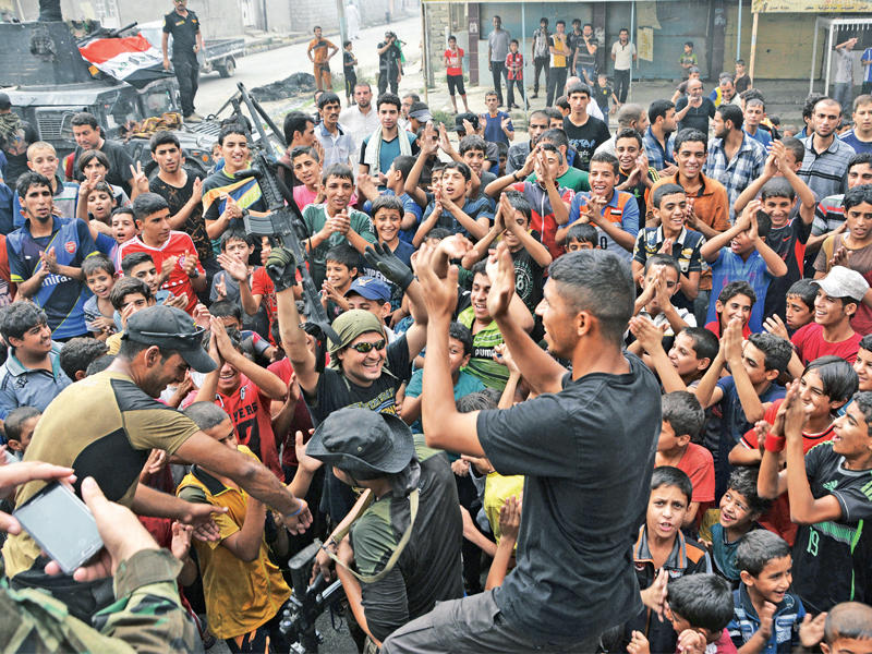 عراقيون يحتفلون بتحرير القيارة أمس الأول (رويترز)