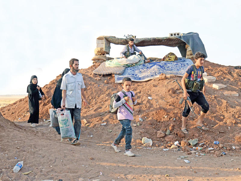 أسرة سورية فارة من المعارك تصل إلى قرية خلفتلي أمس       (أ ف ب)