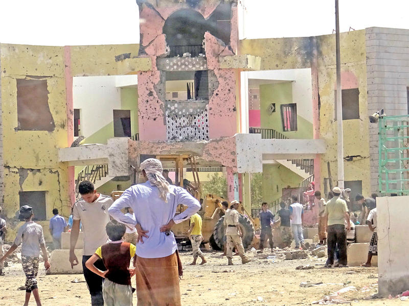 يمنيون داخل المقر الذي شهد الاعتداء في عدن أمس (رويترز)