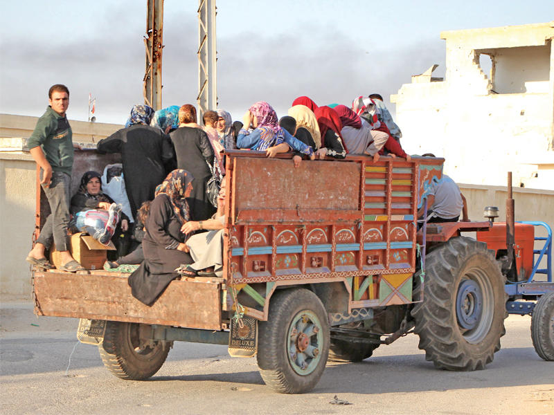 سوريون يغادرون أمس طيبة الإمام مع احتدام المعارك فيها (أ ف ب)