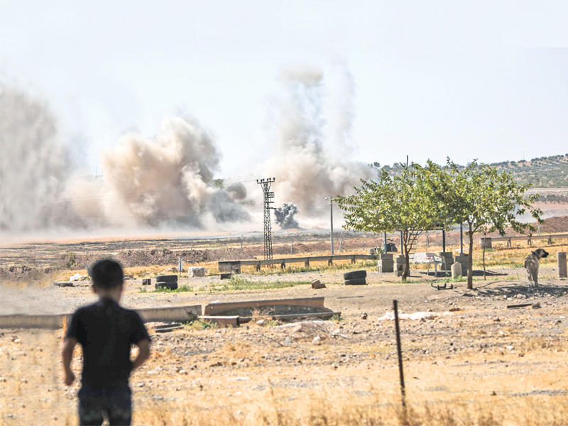 صبي يتابع من الحدود التركية الانفجارات داخل الأراضي السورية أمس (أ ف ب)
