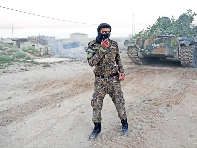 مقاتل من «جيش الإسلام» يستطلع جبهة المواجهة مع النظام في غوطة دمشق يوم الخميس (أ ف ب)