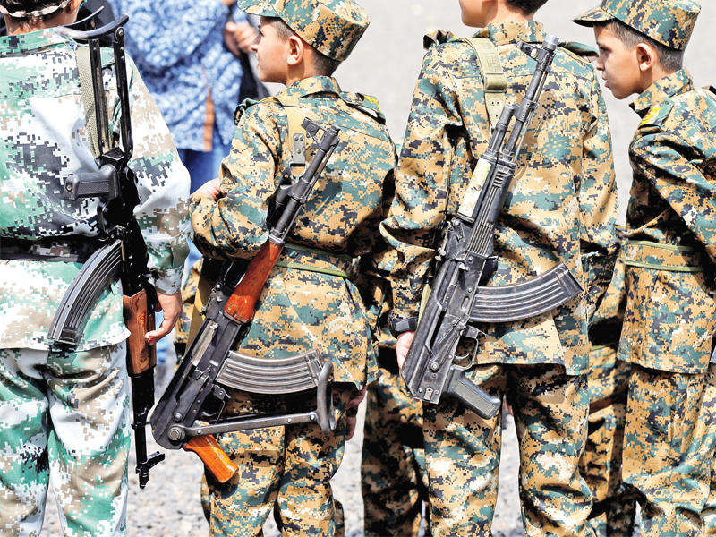 أطفال يحملون بنادق خلال تجمع مسلح ليمنيات من «أنصار الله» في صنعاء أمس (رويترز)