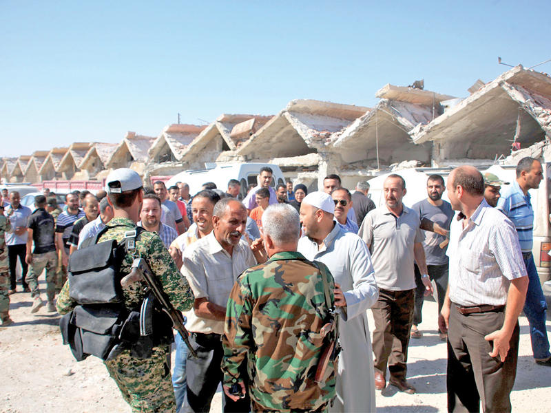 موالون يتحدثون مع جنود النظام في الراموسة جنوب حلب (رويترز)